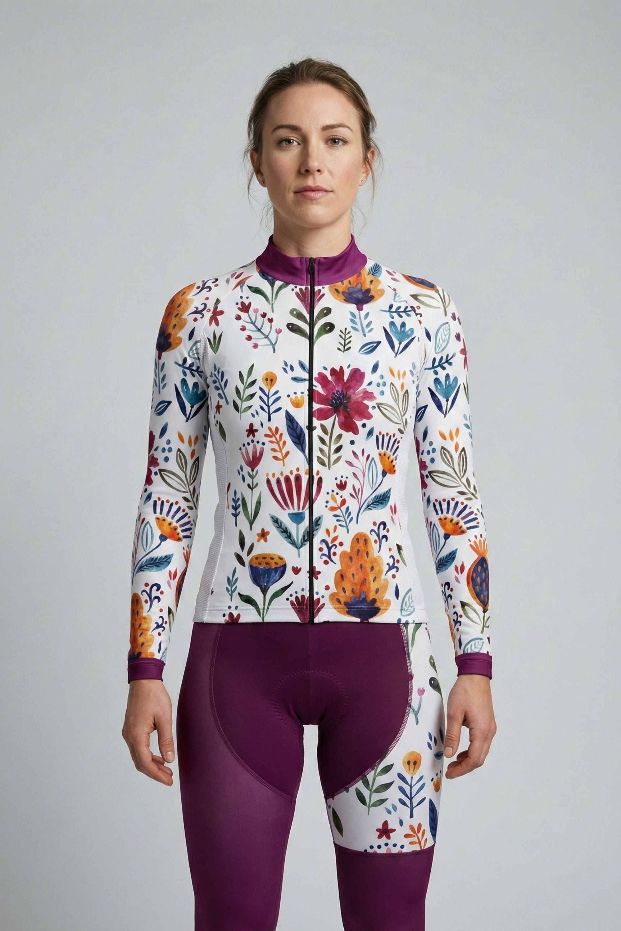 Person wearing a white cycling set with purple flowers accents by Cycling Frelsi on a gray background