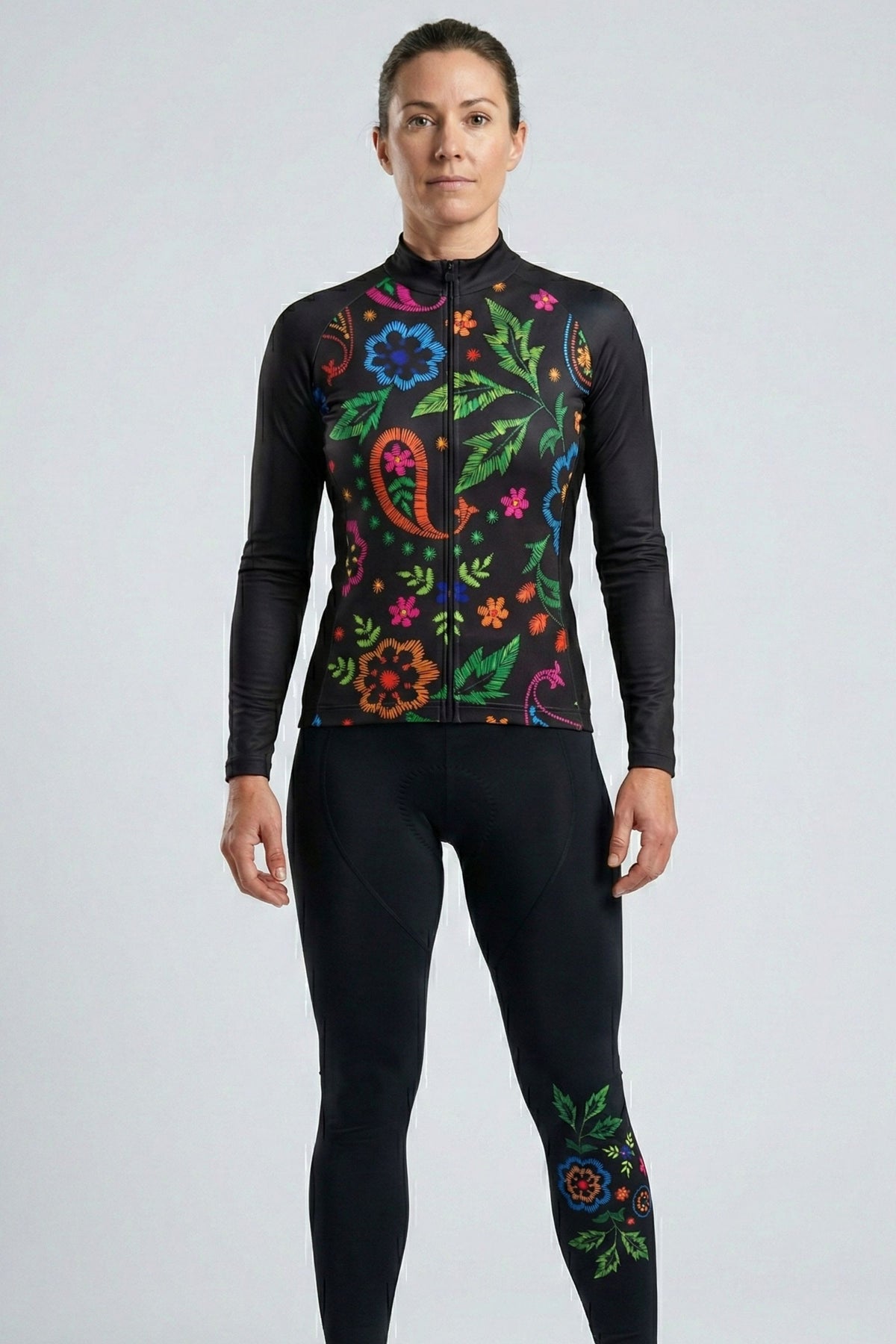Person wearing a black long-sleeve top with colorful floral patterns on a light gray background
