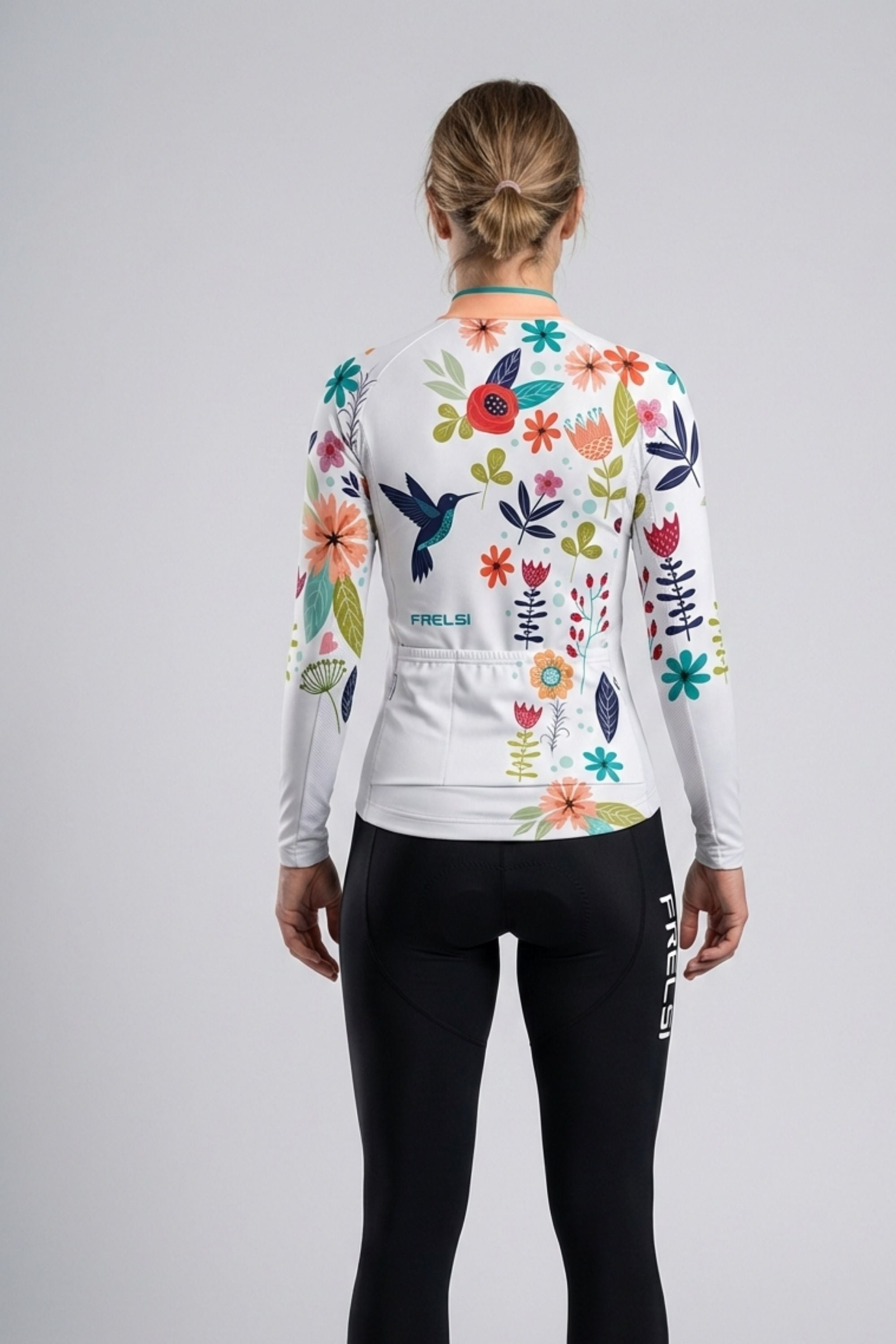 Person wearing a whit cycling jersey with a bird carton accents by Cycling Frelsi on a gray background