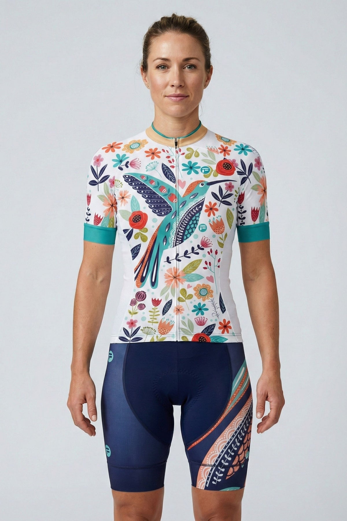 Person wearing a white cycling outfit with blue bird on a plain background by Cycling Frelsi