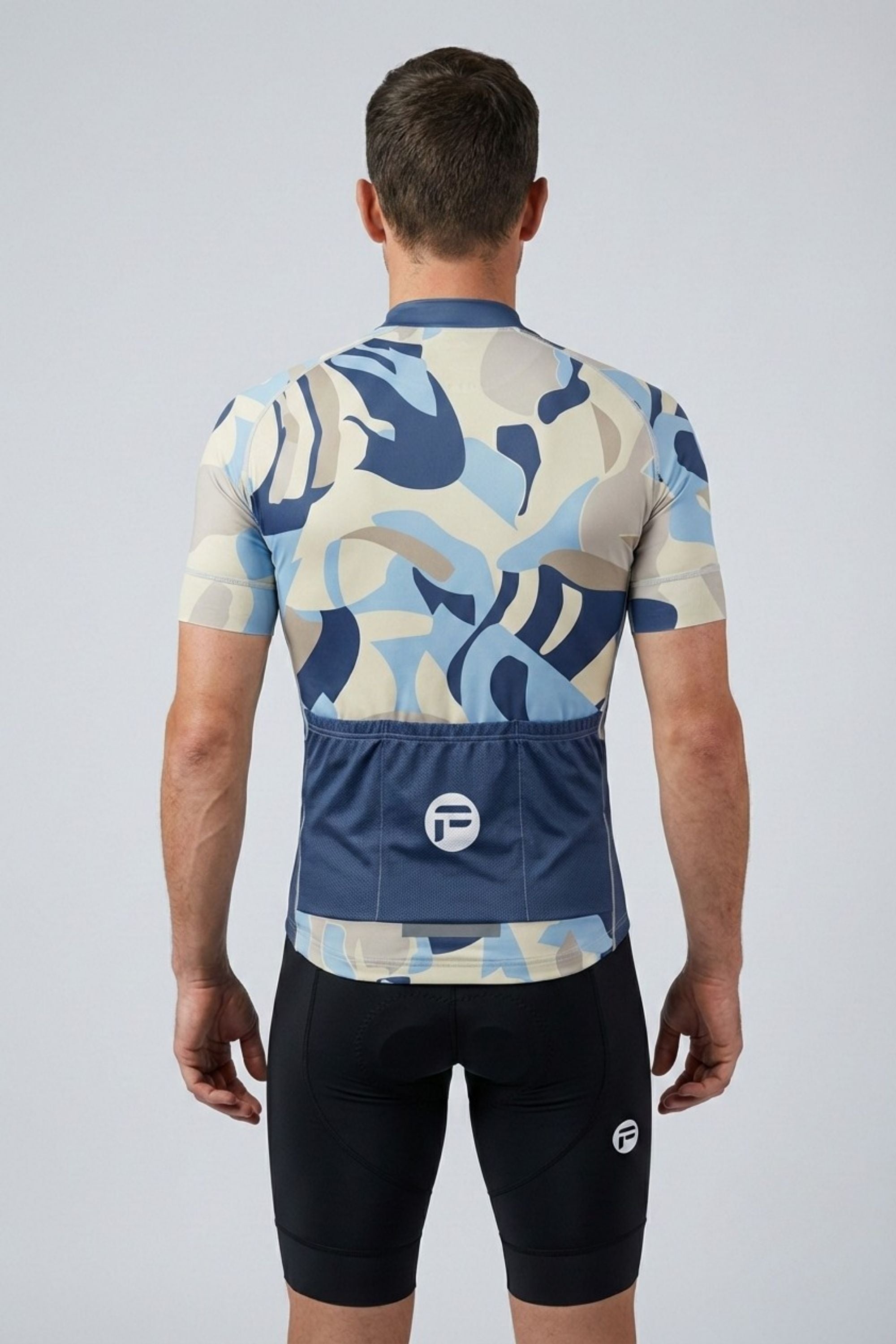Person wearing a blue and beige camouflage cycling outfit on a gray background
