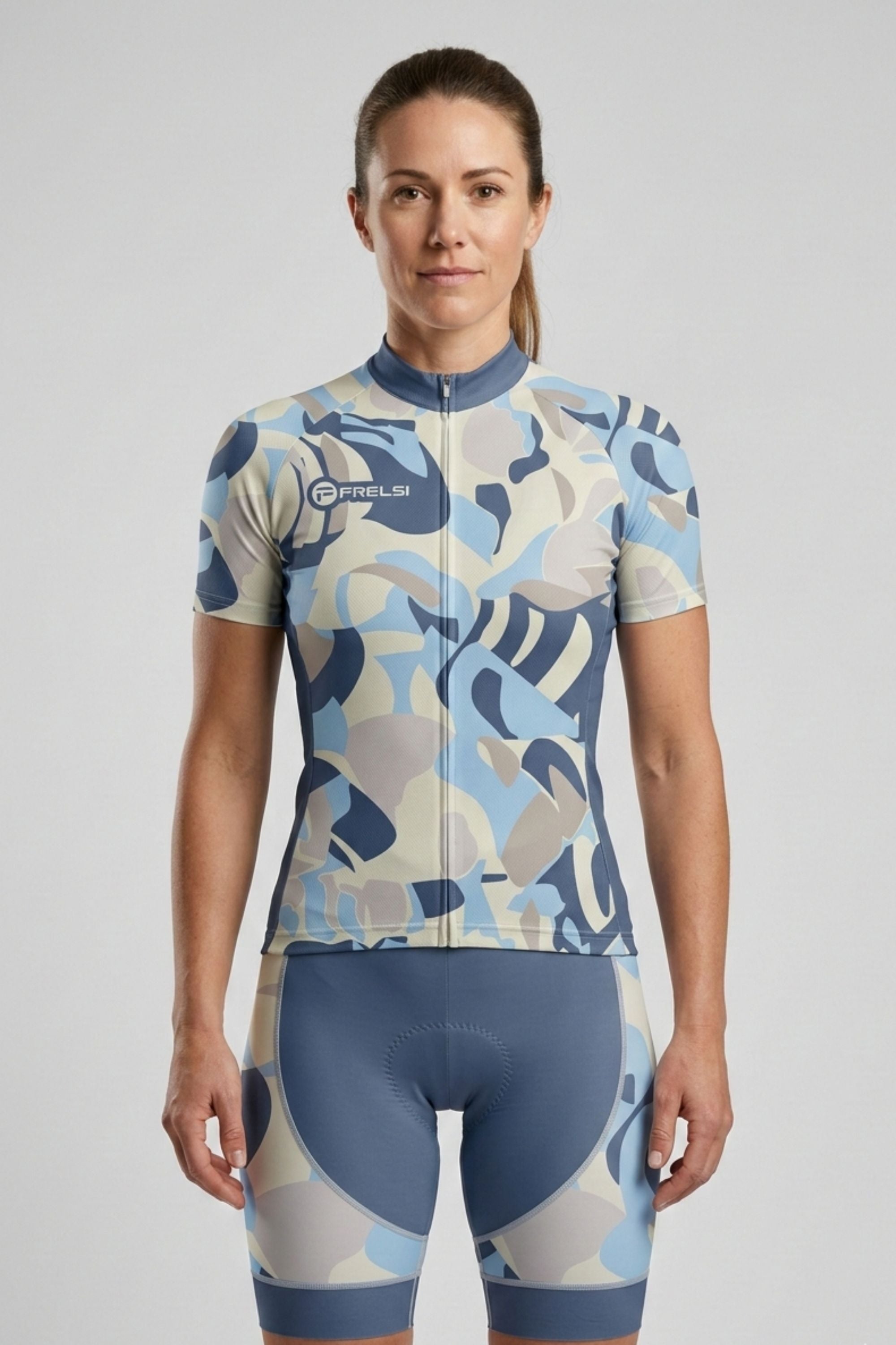 Woman wearing a blue and gray camouflage cycling outfit on a light gray background