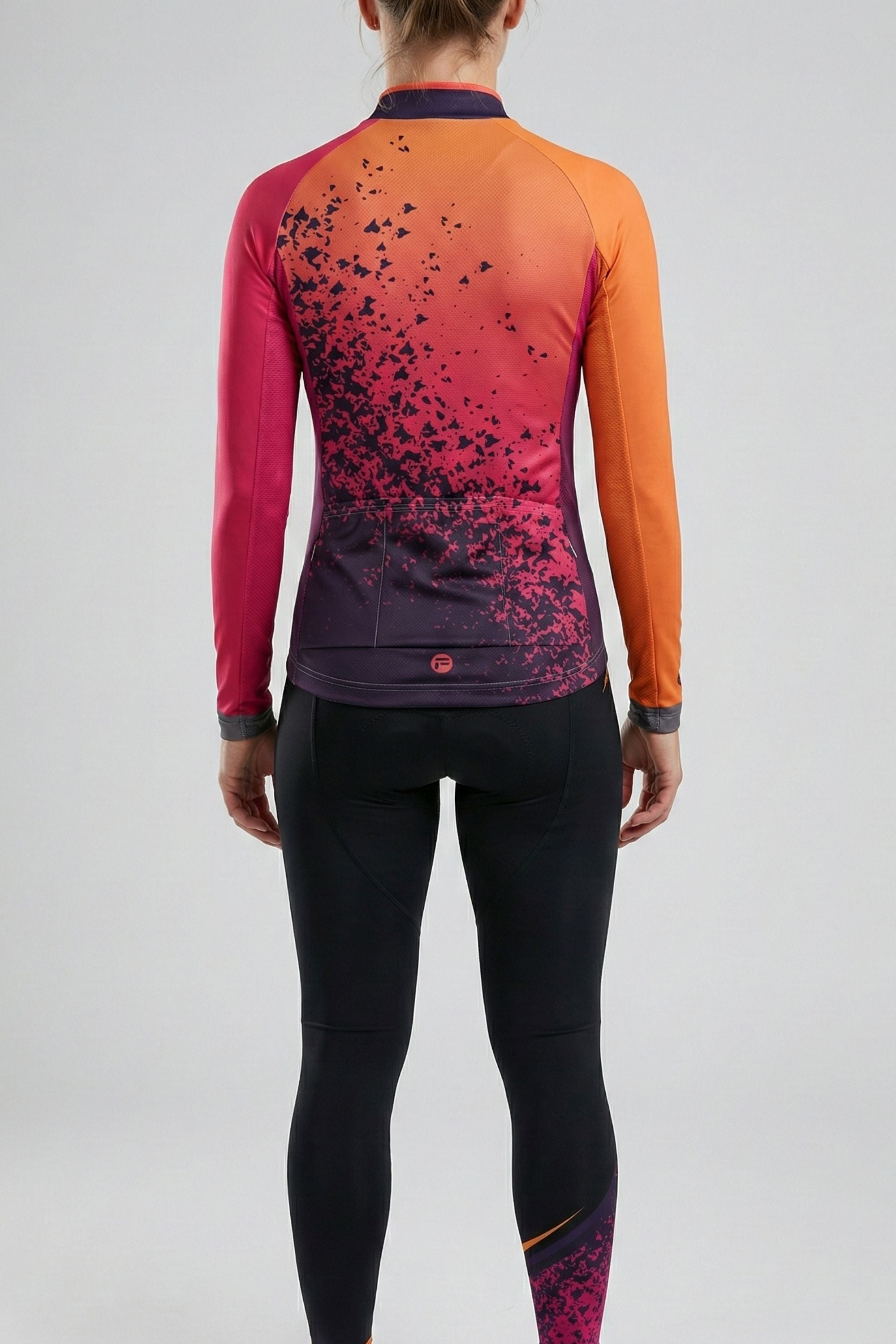 Person wearing a orange cycling set accents by Cycling Frelsi on a gray background