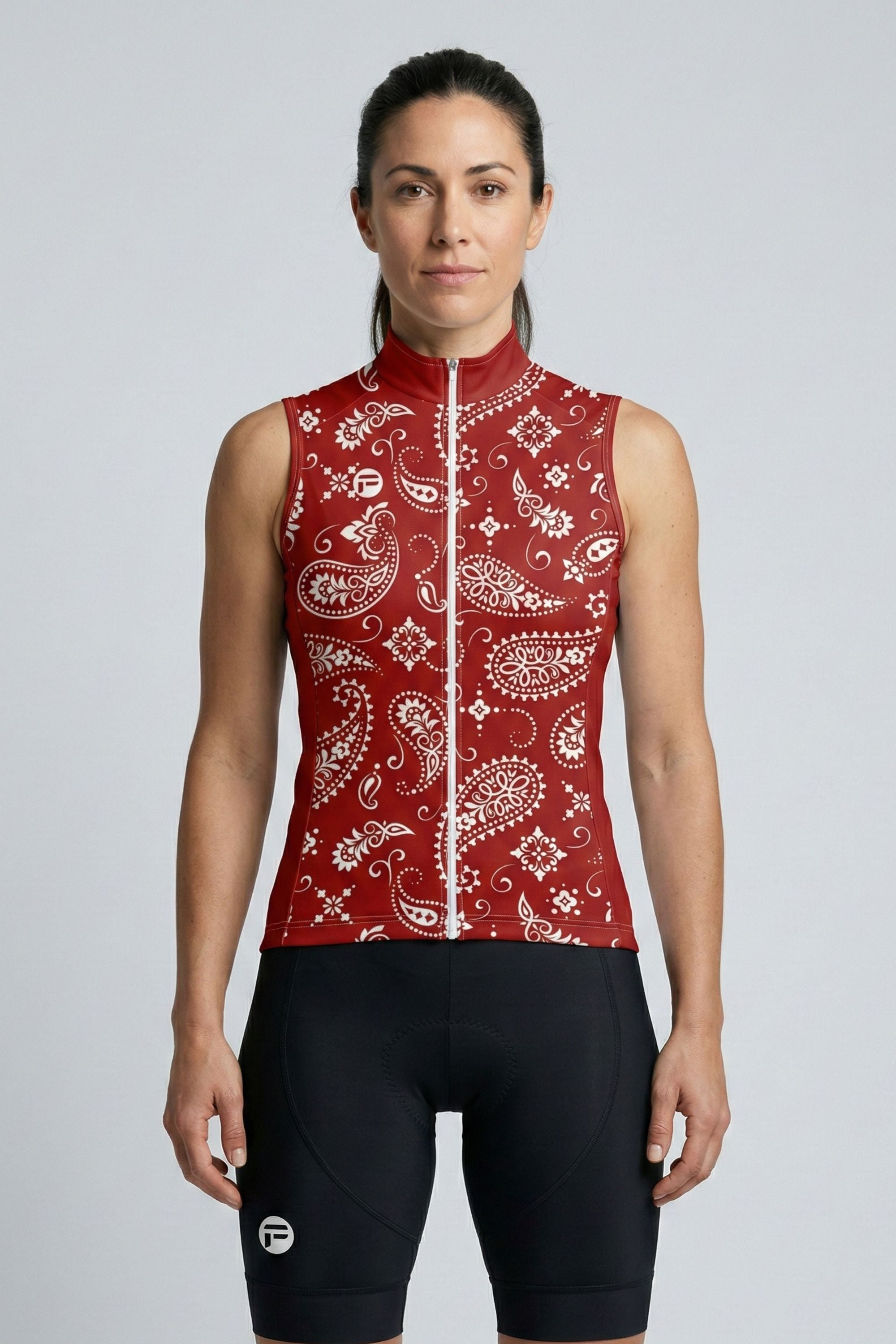 Woman wearing a red paisley patterned sleeveless jacket on a gray background