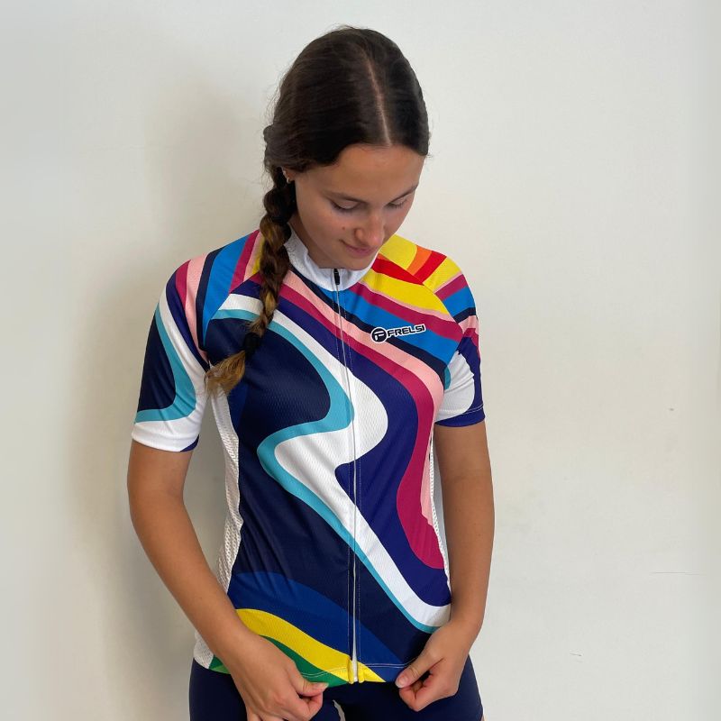 Female cyclist in a vibrant patterned Rainbow Sprinter jersey.