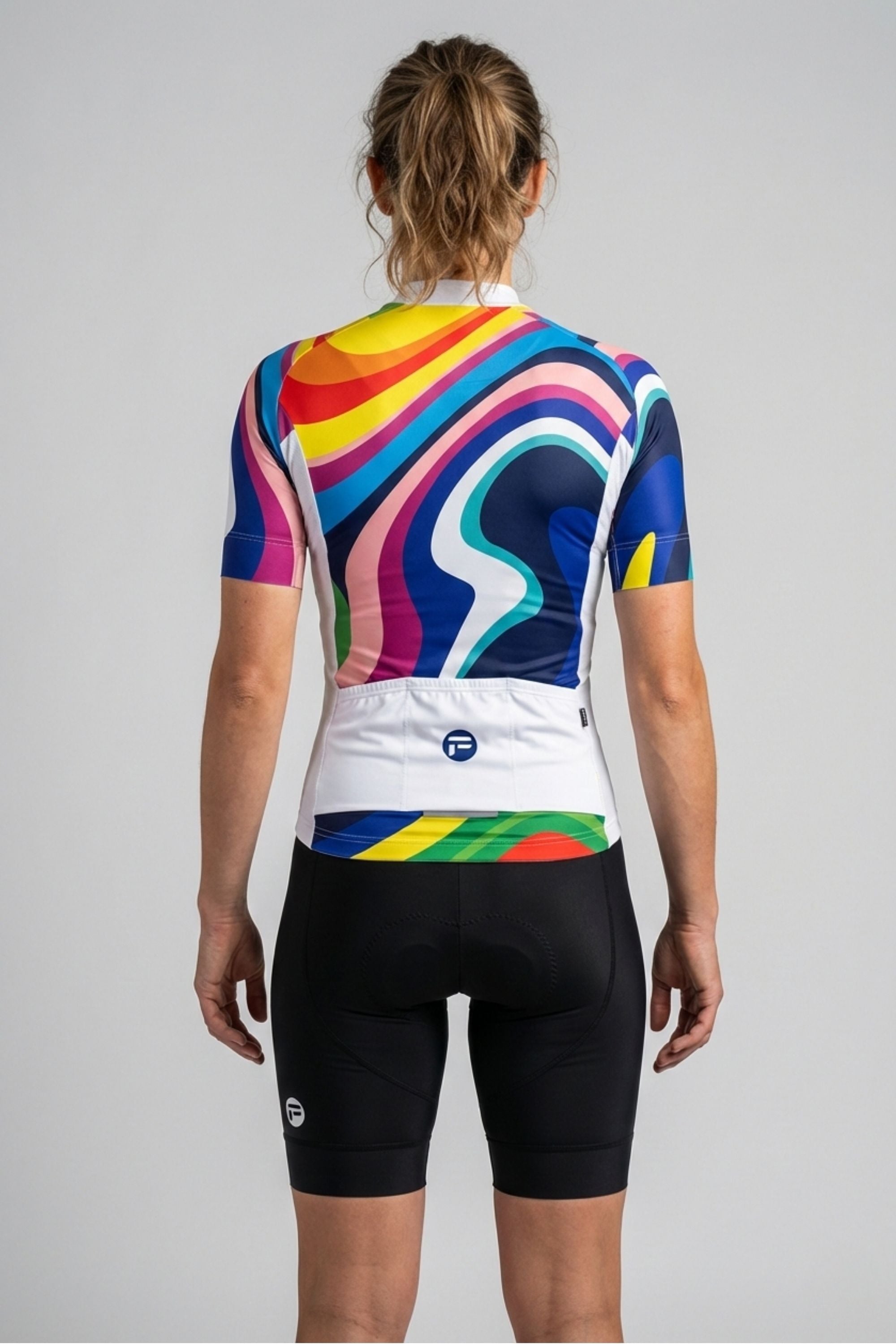 Person wearing rainbow colors cycling jersey accents by Cycling Frelsi on a gray background