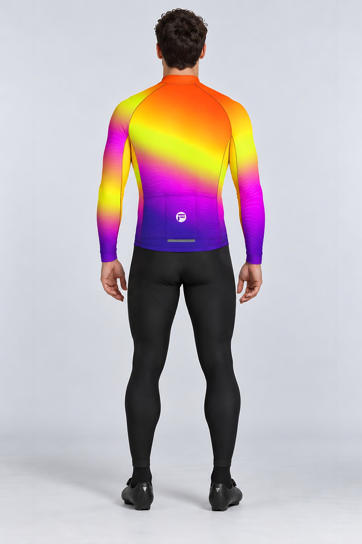 Man wearing the Sunset Pulse long sleeve cycling jersey with black bib tights - back view