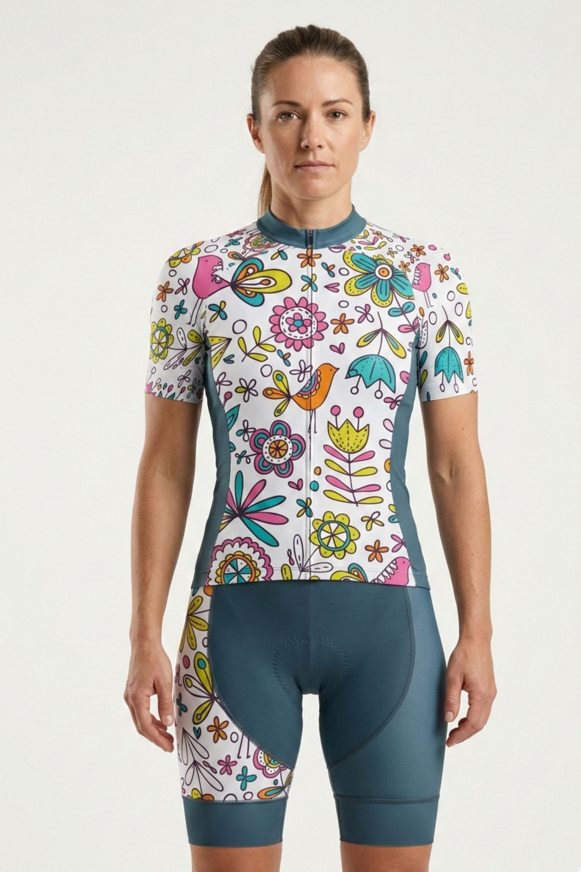 Woman wearing a colorful floral cycling outfit on a white background