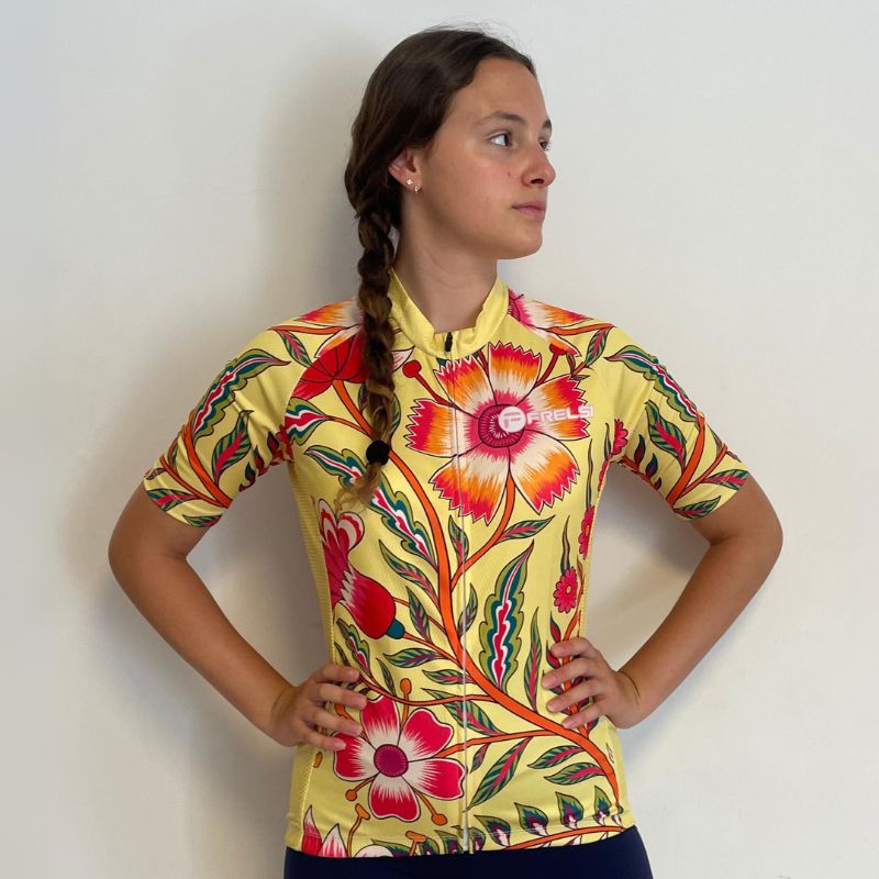 Happy young female cyclist wearing a patterned Wildflower Ride jersey.