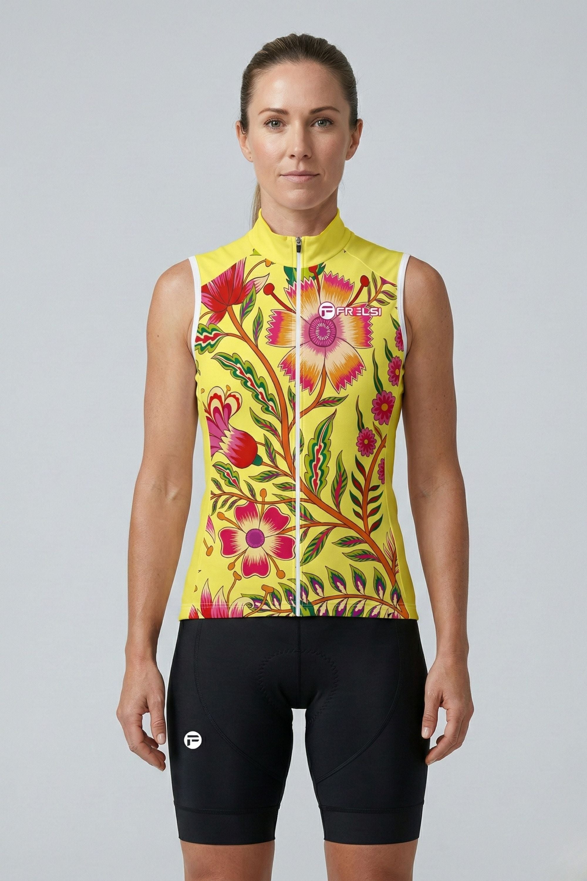 Woman wearing a colorful floral cycling jersey and black shorts on a gray background